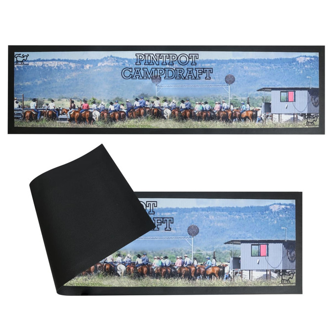 A long counter mat featuring a horse event scene with a black underside. It includes a logo and vibrant colours.