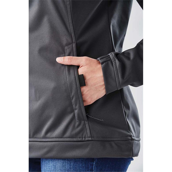 A black women's anorak jacket featuring a side pocket and a fitted design. The model has a hand in the pocket.