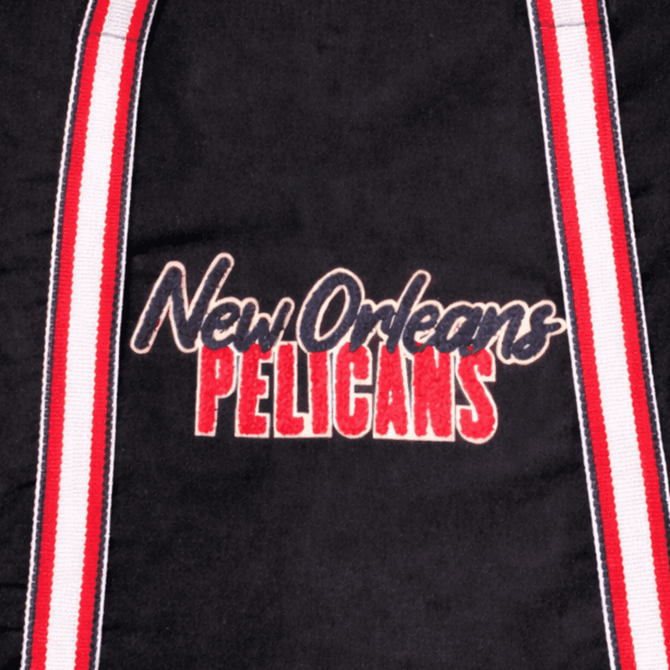 A black tote bag featuring a logo and red and white striped straps.