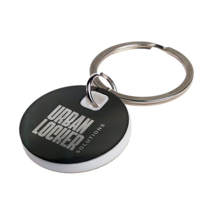 A circular stainless steel keytag in black and white, attached to a metal keyring. It features a logo.