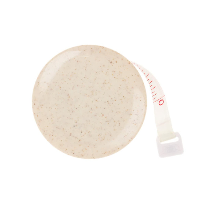 A beige tape measure made from wheat fibre, featuring a retractable measuring tape. It has a small branding logo.