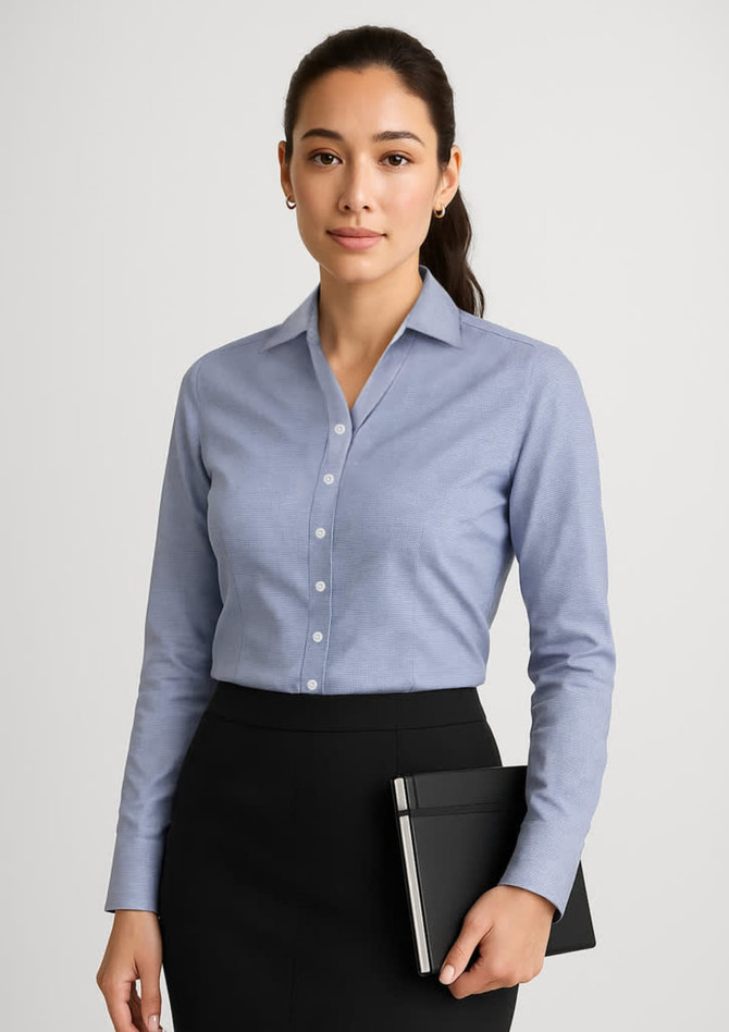 A long sleeve button-up shirt in a light blue colour, paired with a black skirt, held with a notepad. The shirt features a subtle logo.