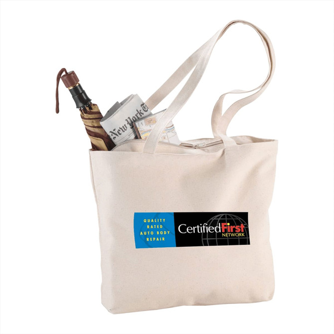 A zippered cotton canvas shopper tote in beige, featuring an umbrella and rolled newspaper inside, with a logo.