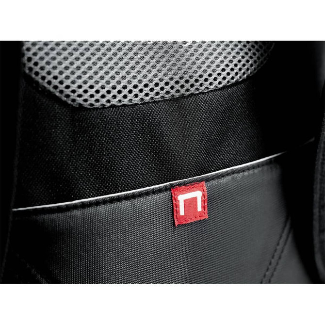 A close-up of a black backpack featuring a red logo tag and a textured mesh pocket.