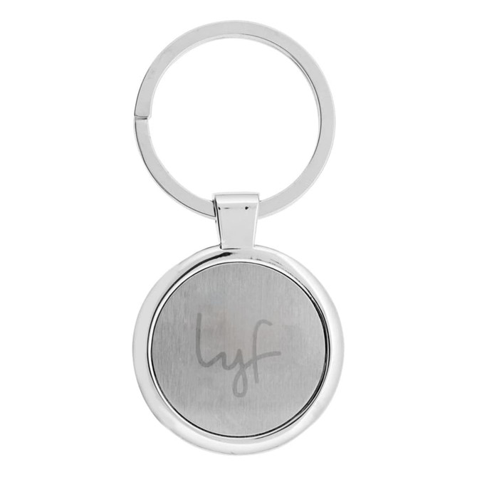 A silver keychain with a circular design featuring a branding logo on one side.