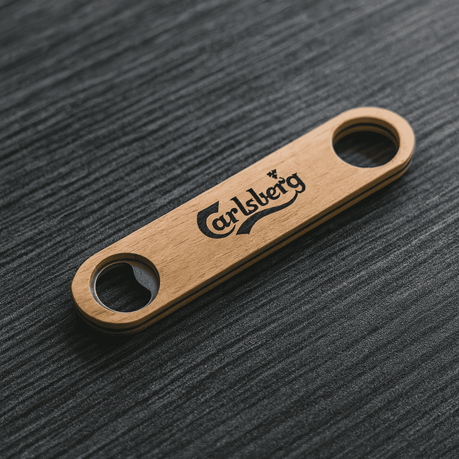 A bamboo bottle opener in a natural wood colour, featuring a logo and two openings.