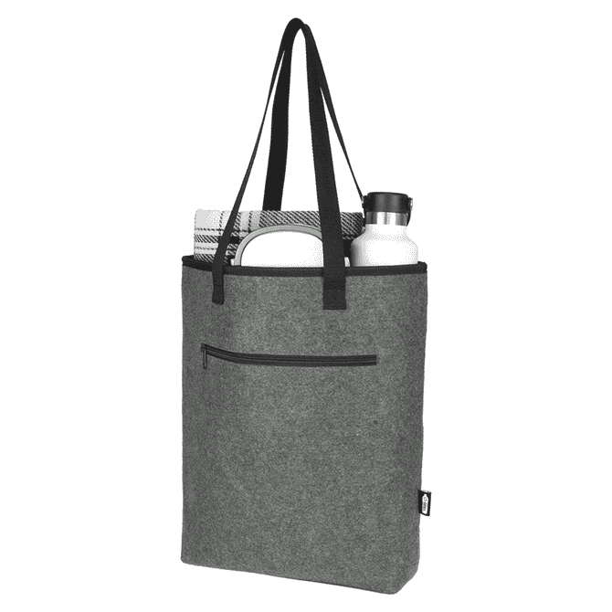 A grey recycled felt cooler tote bag contains a drink bottle, a towel, and features a pocket and black handles.
