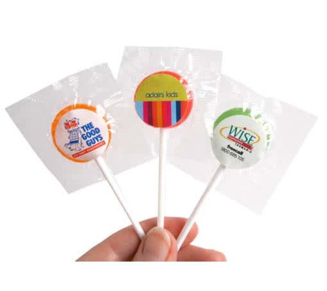 A hand holding three small lollipops with colourful branding on their wrappers.