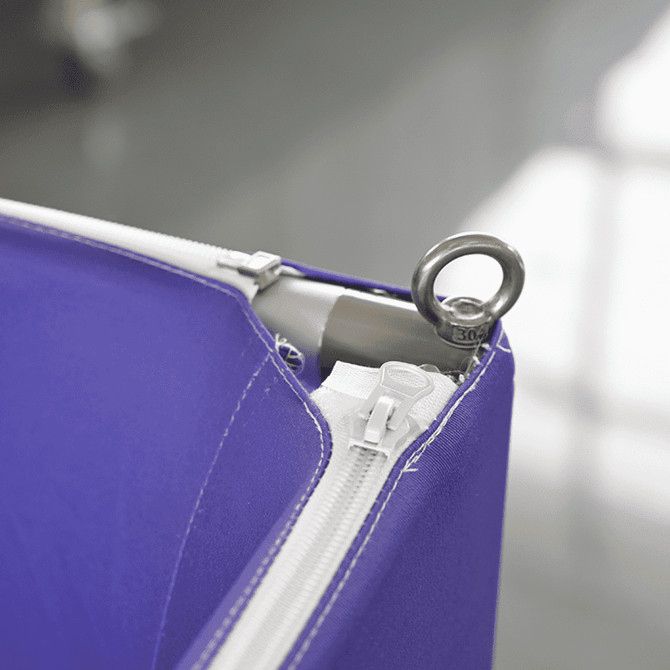 A purple hanging banner featuring a zipper and a metallic ring for attachment.