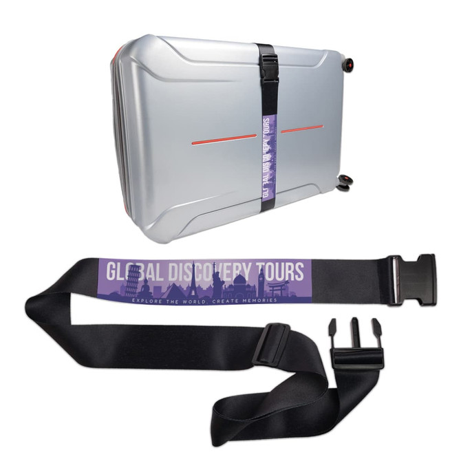 A silver suitcase secured with a black luggage strap featuring a logo and a colorful design.