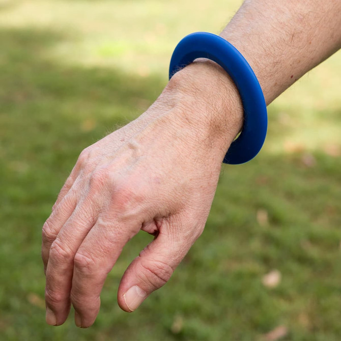 A blue silicone wrist flyer is worn on a person's wrist.