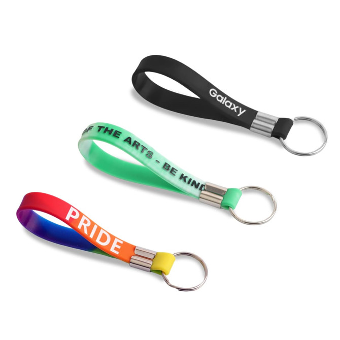 Three silicone key rings in black, green, and a rainbow gradient, each featuring metallic keyring attachments.