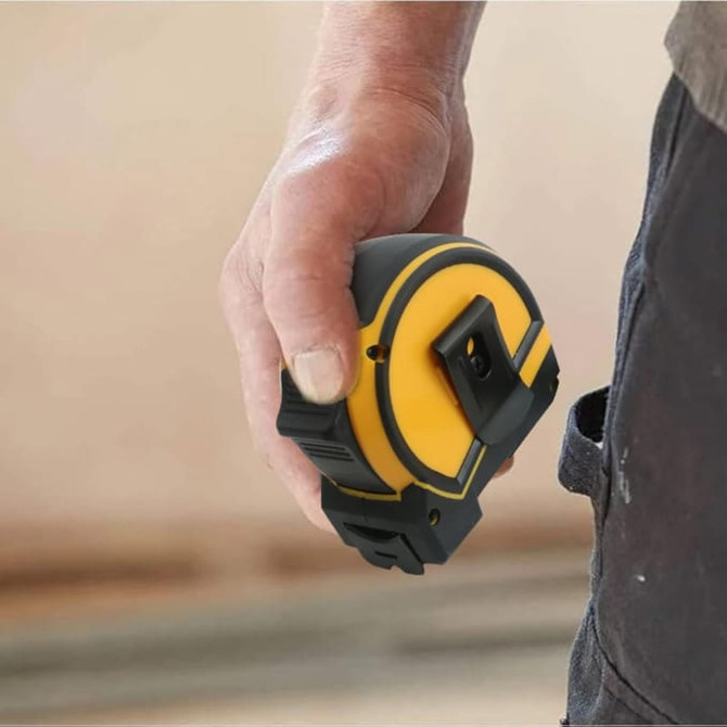 A tape measure featuring a yellow and black design, held in a hand, showing its compact and sturdy build.