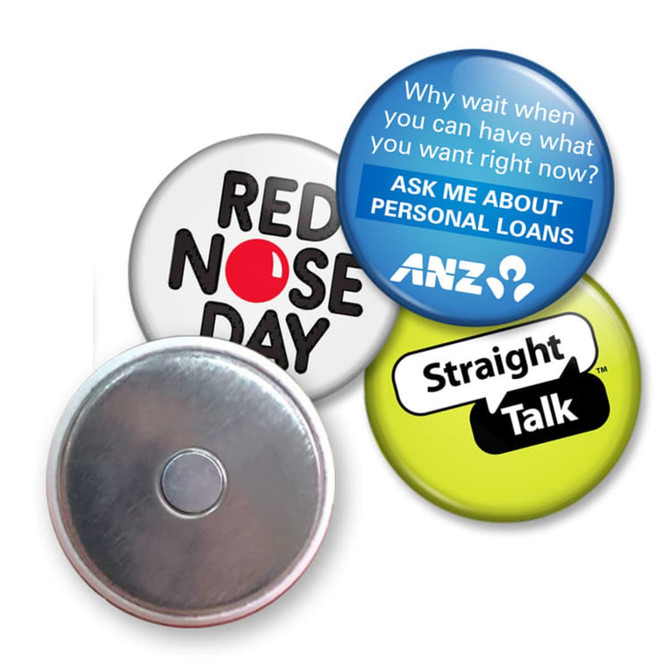 A collection of four button badges featuring various colours, designs, and a metallic backing.