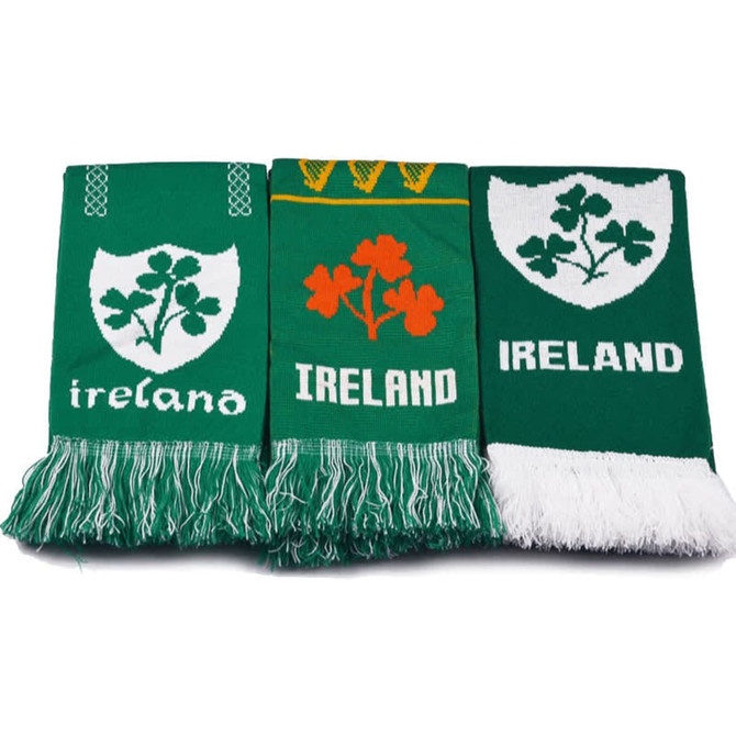 Three green custom knitted scarves featuring various designs, including shamrocks and the word "Ireland."
