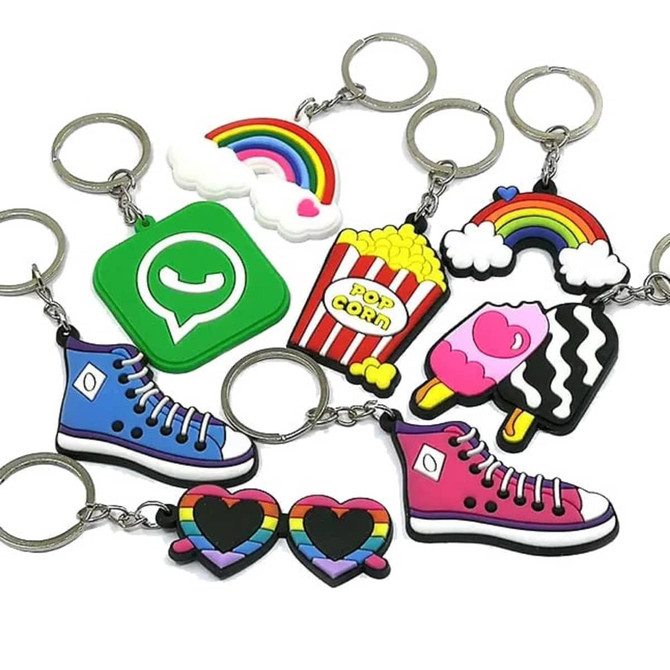 A collection of colourful PVC soft keyrings featuring designs like shoes, popcorn, rainbows, and hearts, with silver keyring attachments.