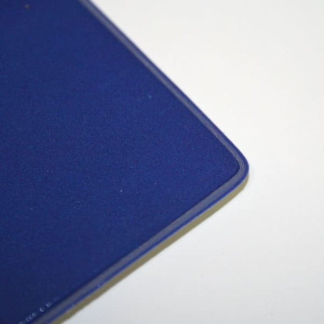 A blue welded mouse mat with a smooth surface and rounded edges. It features a subtle logo in one corner.