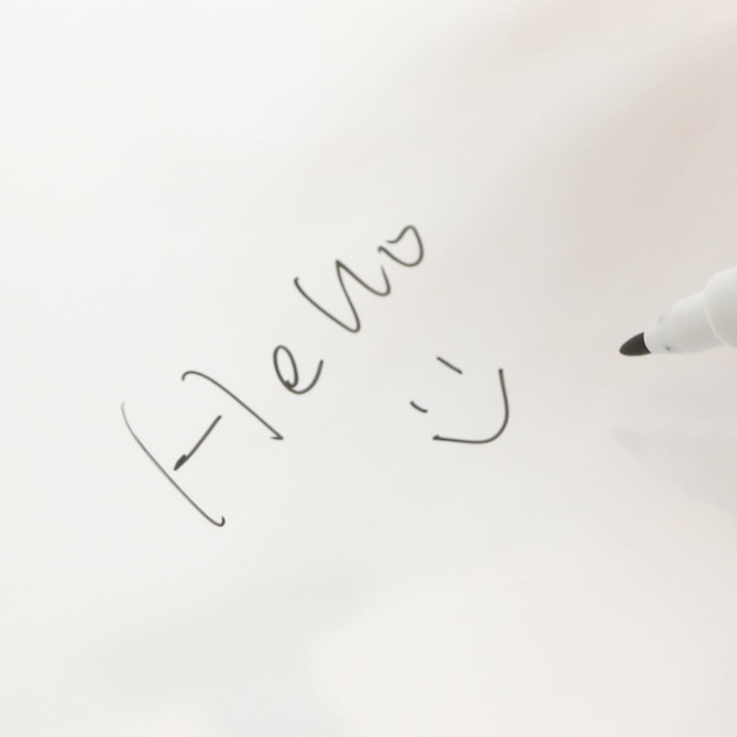 A5 whiteboard notebook featuring a handwritten note and smiley face, with a black marker on a white background.