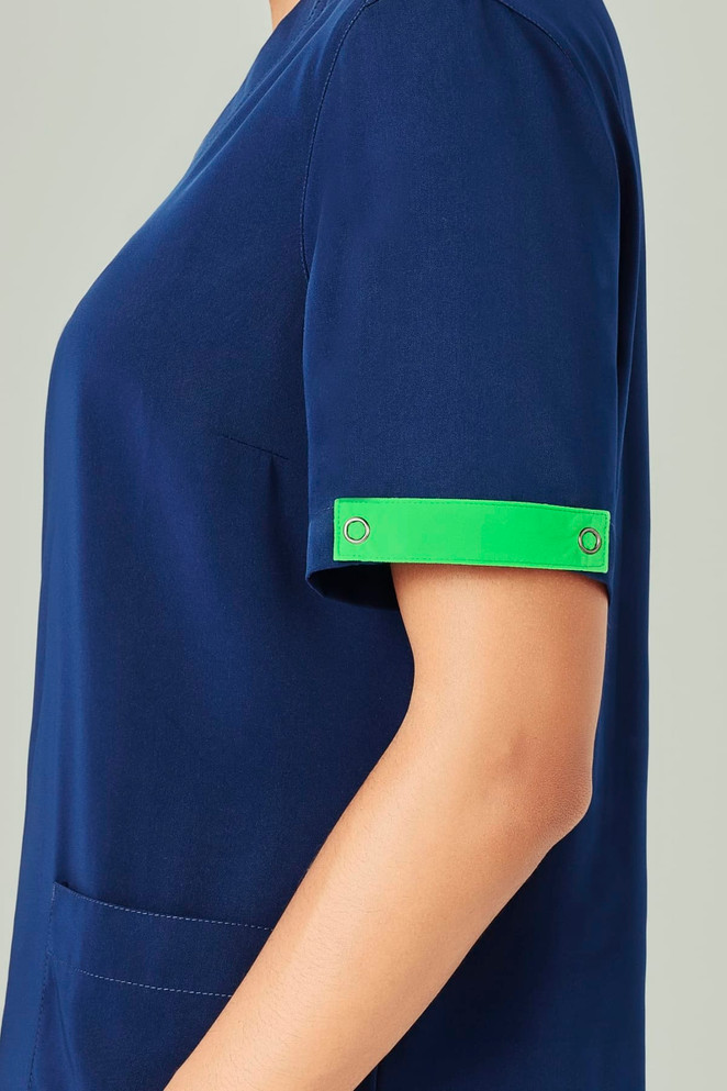 A navy blue scrub top with short sleeves featuring a bright green arm band and a pocket.
