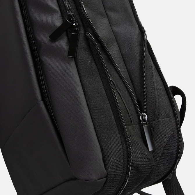 A black Kaden Soft Touch Backpack with smooth zippers and a sleek design. It features a logo on the side.