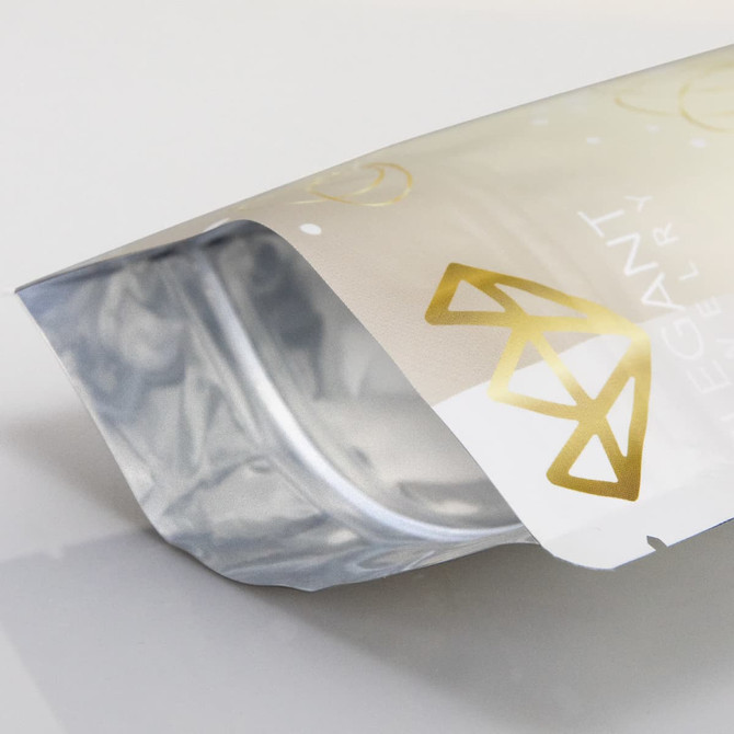 A foil stand-up pouch in silver and white with a glossy finish and a logo at the front.