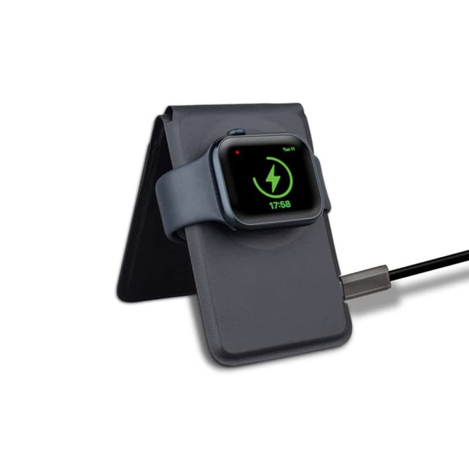 A grey magnetic card wallet and wireless charging stand with a smartwatch resting on it, connected by a charging cable.