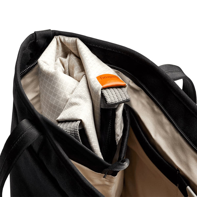 A black cooler bag with a cream interior, featuring a zippered opening and a logo tag.