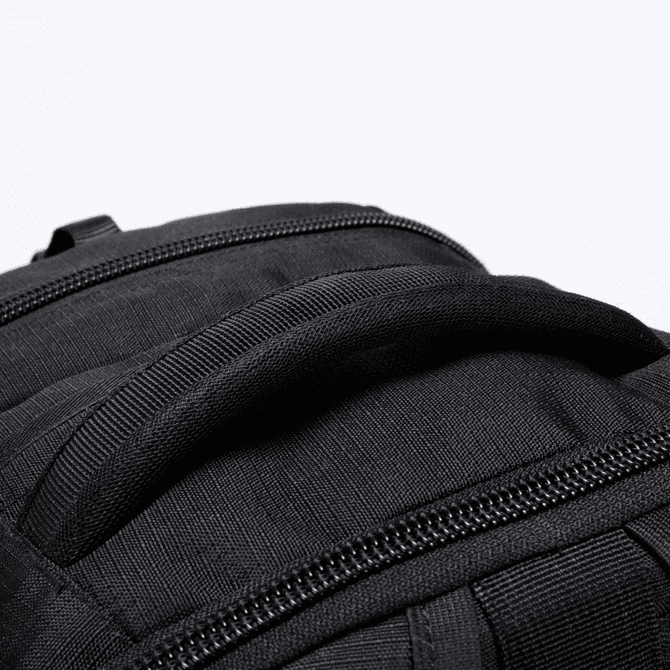A black backpack featuring a sturdy handle and zippers. It is designed for durability and functionality.