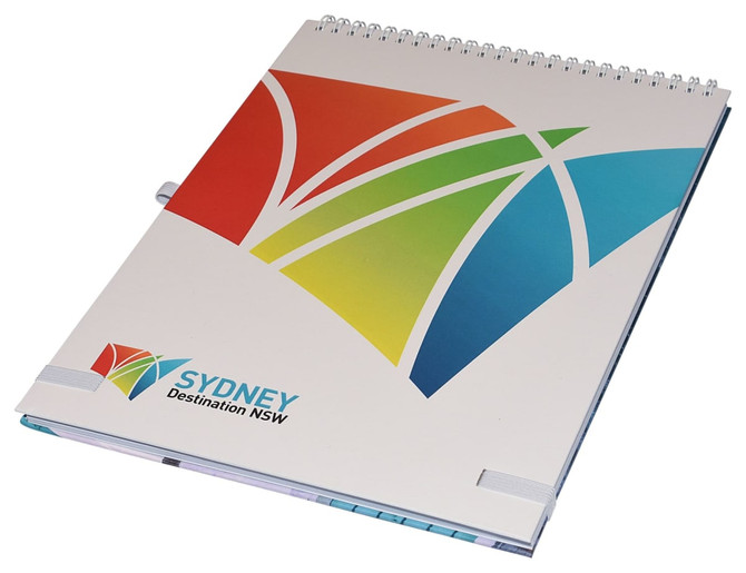 A top-bound A4 notebook with a colourful abstract design and a logo on the cover. Features a spiral binding.