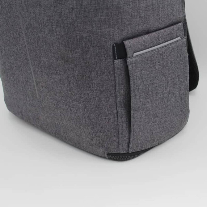 A grey backpack with a side pocket and a logo. The fabric has a textured appearance, adding to its style.