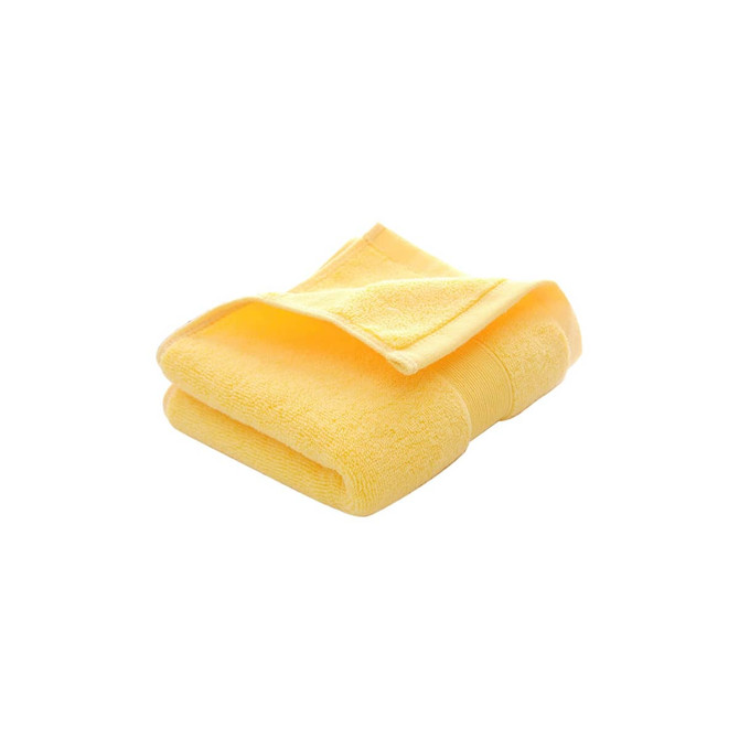 A folded embroidered cotton hand towel in a vibrant yellow colour, featuring a textured surface and a logo.
