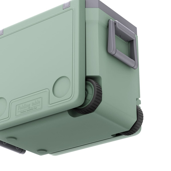 A green cooler box with wheels and a folding table, featuring a grey handle. Includes branding on the side.