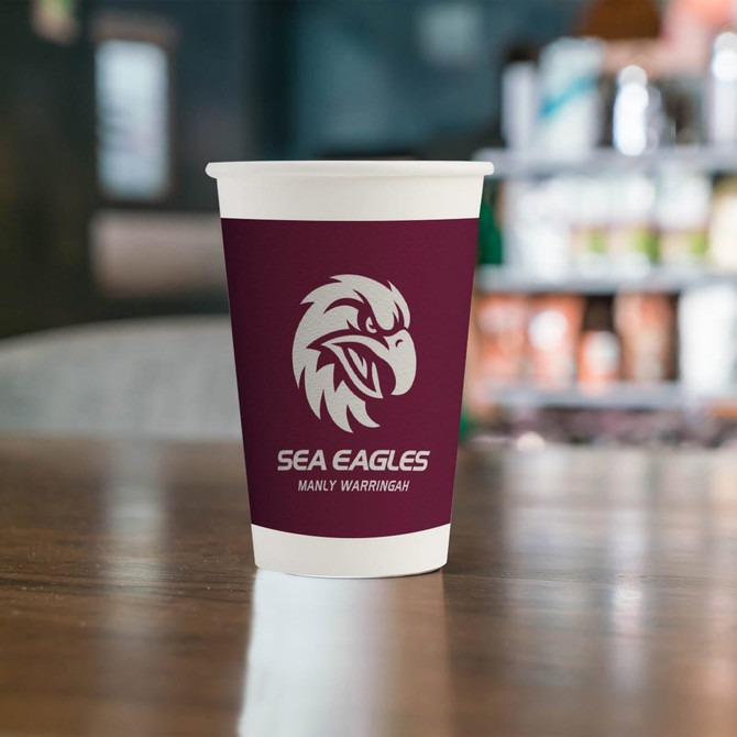 A single wall paper cup in maroon featuring a logo, set against a blurred background of a café environment.