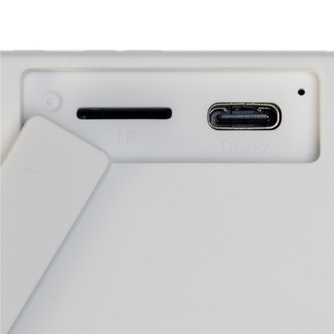 A white speaker featuring a stand and ports for connectivity, including a USB-C port.