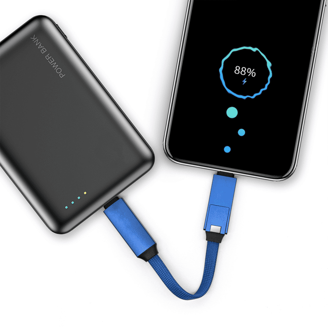 A black power bank with blue charging cable connected to a smartphone, displaying an 88% battery charge.