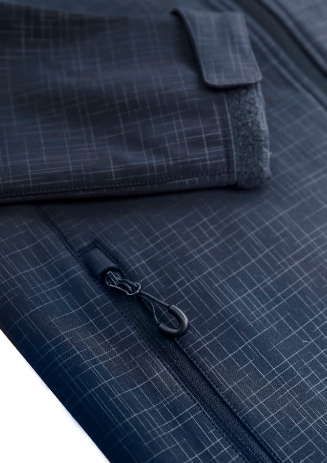 A close-up of a women's navy blue soft shell jacket displaying a textured pattern and zip details. Features a pocket.