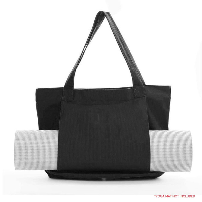 A black canvas bag with a yoga mat rolled up and secured on the side. The bag features two handles and a logo.