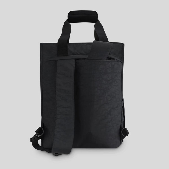 A black tote pack with adjustable straps and a structured design, featuring a front zip pocket and a top handle.