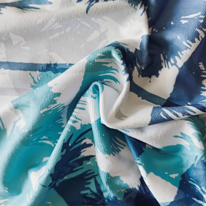 A hooded change towel in shades of blue and white featuring a vibrant abstract pattern and a logo.