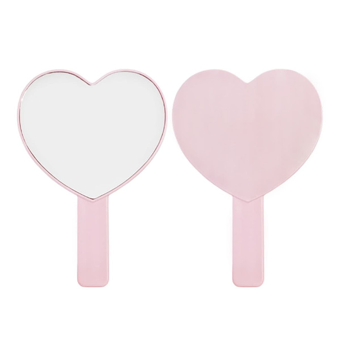 A heart-shaped handheld mirror in pink with a smooth handle, featuring a reflective surface on one side.