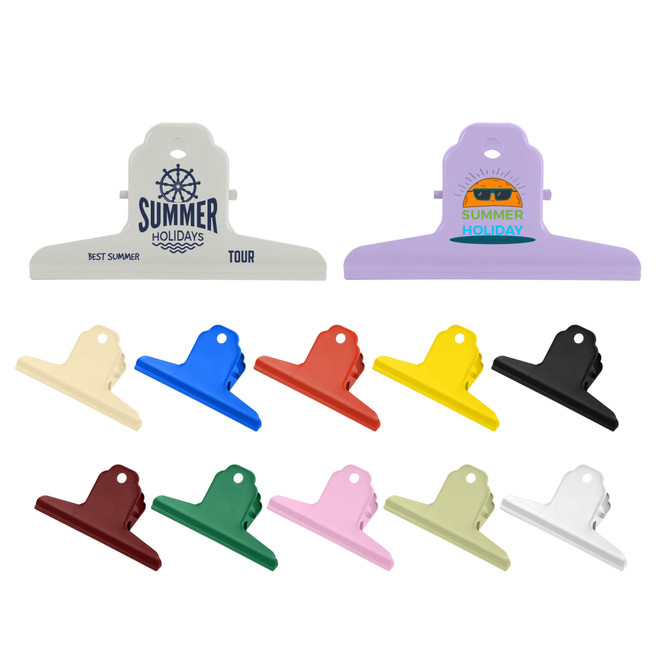 A variety of metal binder clips in colours including black, yellow, blue, white, and cream, arranged in a row.