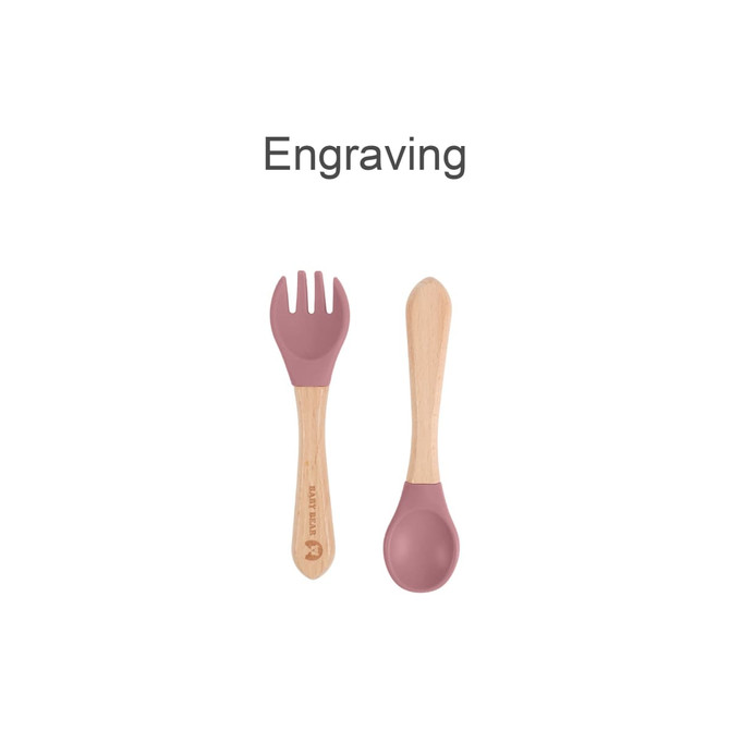 Ergonomic silicone kids cutlery set featuring a pink fork and spoon with wooden handles. Includes a logo.