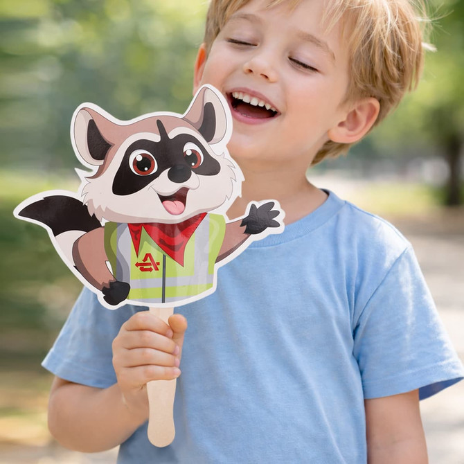 A paper hand fan in the shape of a cartoon raccoon, held by a smiling child, featuring a wooden handle.
