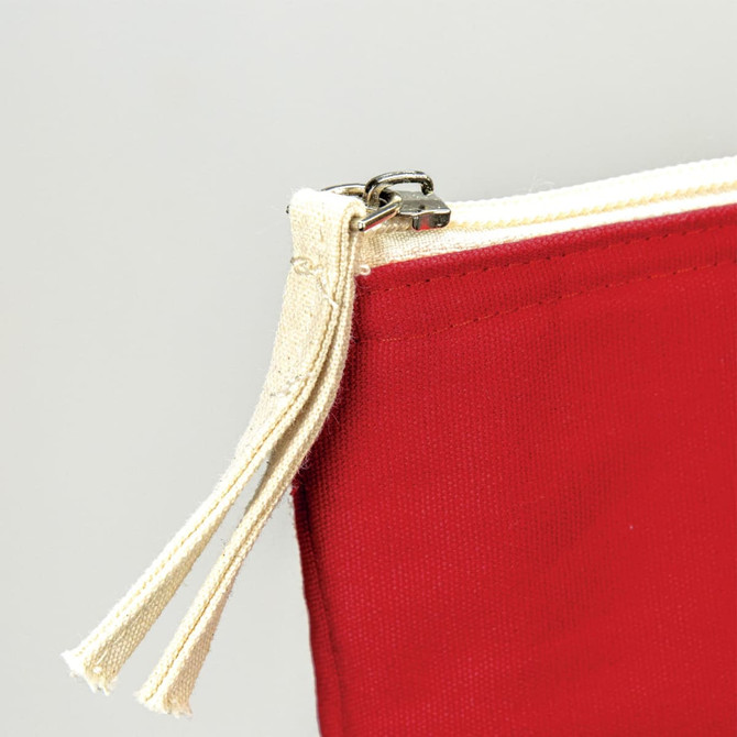 A close-up of a red cotton tote bag featuring a cream zipper with double pulls. It has a logo on the side.