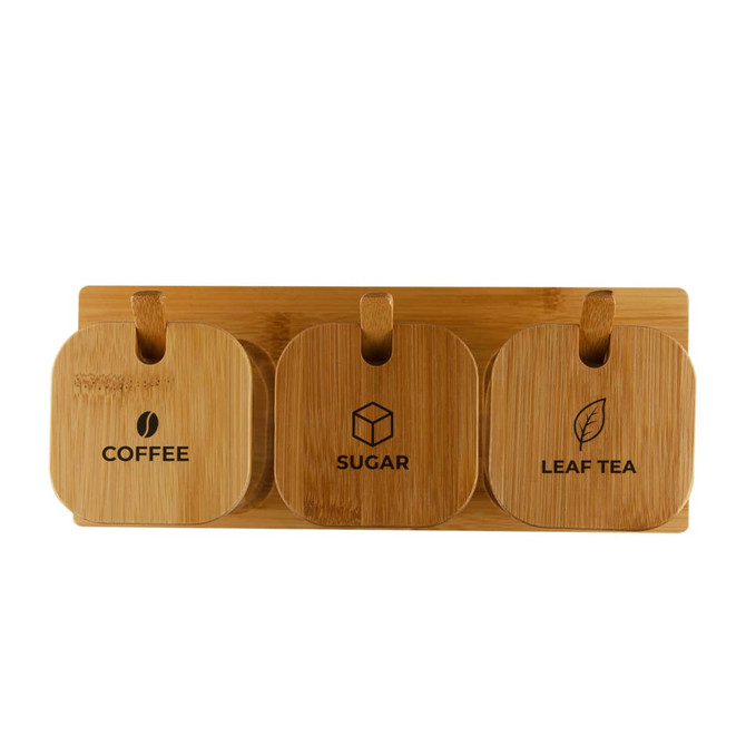 Three bamboo jars labelled for coffee, sugar, and leaf tea, mounted on a wooden base. Each jar has a circular design.
