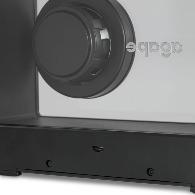 A black speaker with a circular driver, featuring a minimalistic design and a visible logo.