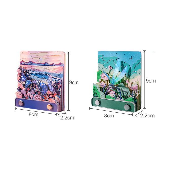 A 3D paper-cut sculpture notepad featuring colourful landscapes with butterflies and flowers, in blue and green hues.