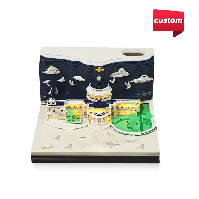 A 3D paper carving notepad featuring a detailed architectural design in multiple colours, including white, blue, and green.