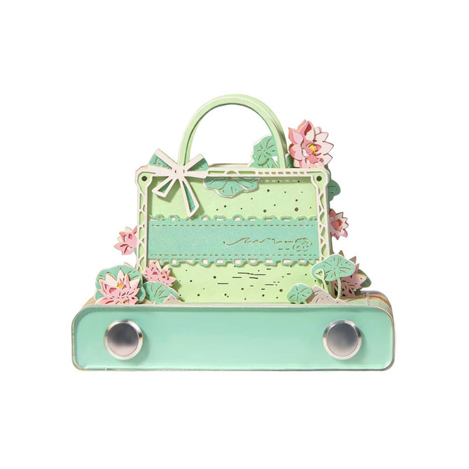 A green 3D paper art handbag tear-off notepad featuring pink floral accents and a decorative handle.