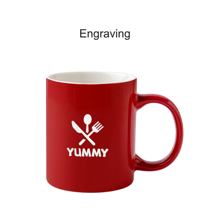 A red ceramic mug with a white logo featuring utensils and the word "YUMMY." The mug has a smooth finish and a handle.